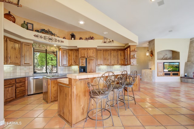 kitchen featuring tasteful backsplash, stainless steel dishwasher, and a kitchen island