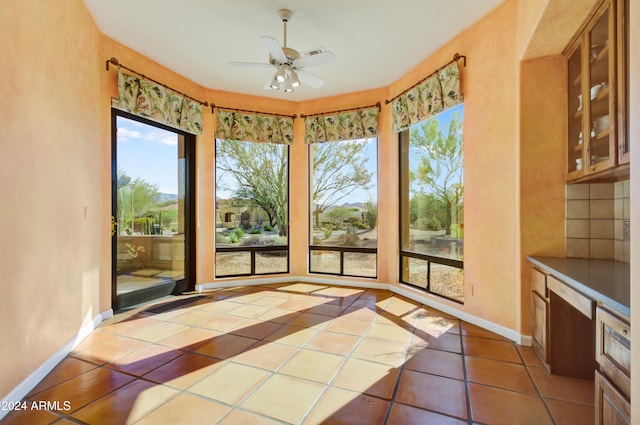 unfurnished sunroom featuring ceiling fan