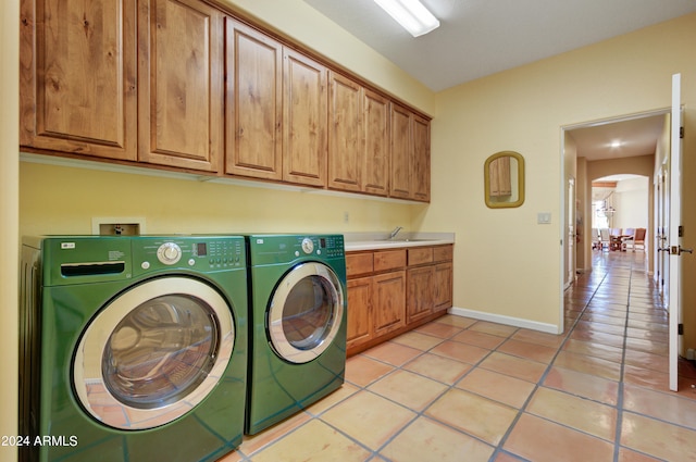 laundry room with sink, cabinets, light tile patterned floors, and separate washer and dryer