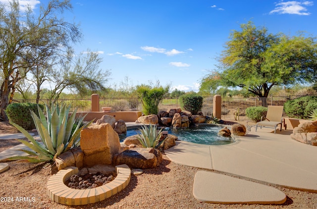 view of pool with pool water feature and a patio