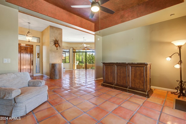 living room featuring ceiling fan, a high ceiling, and tile patterned flooring