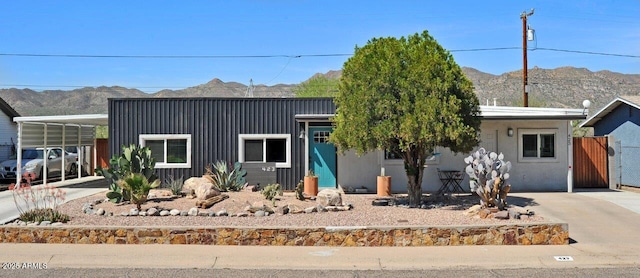 view of front of home with a mountain view, board and batten siding, concrete driveway, and an attached carport
