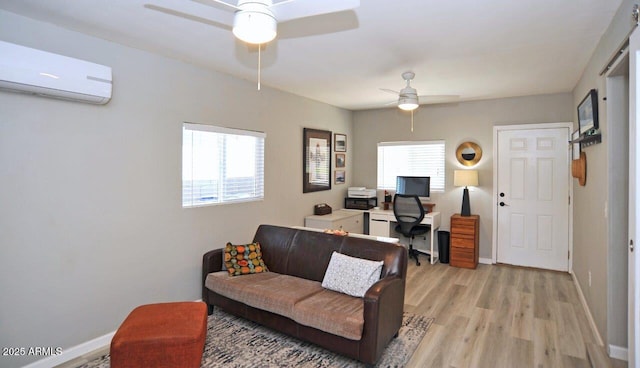 living room with light wood-type flooring, a ceiling fan, baseboards, and a wall mounted AC