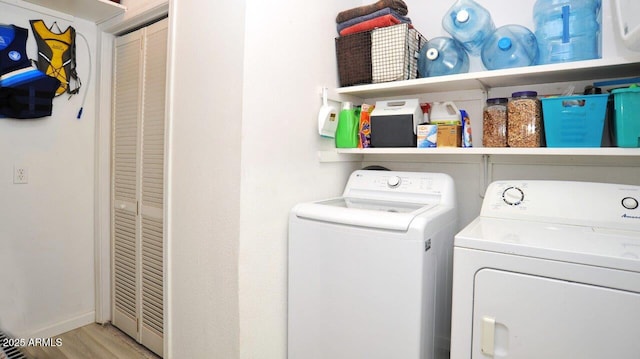 laundry room featuring separate washer and dryer, laundry area, baseboards, and light wood finished floors