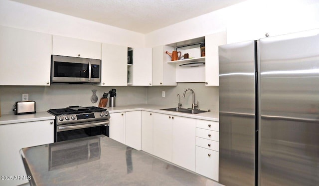 kitchen with open shelves, a sink, appliances with stainless steel finishes, and white cabinets