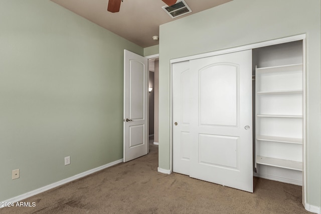 unfurnished bedroom featuring light carpet, a closet, and ceiling fan