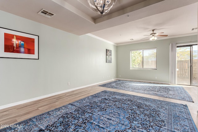 empty room with wood-type flooring, ceiling fan, and crown molding