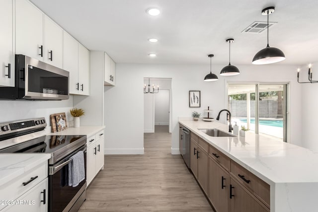 3008 S Saguaro Cir, Mesa, AZ 85202 - kitchen with appliances with stainless steel finishes, a sink, a chandelier, light wood-style flooring, and baseboards