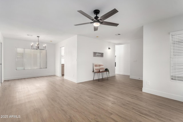 3008 S Saguaro Cir, Mesa, AZ 85202 - unfurnished living room featuring a chandelier, light wood finished floors, baseboards, and a ceiling fan