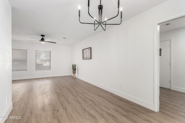 3008 S Saguaro Cir, Mesa, AZ 85202 - unfurnished living room with light wood finished floors, a chandelier, ceiling fan, and baseboards