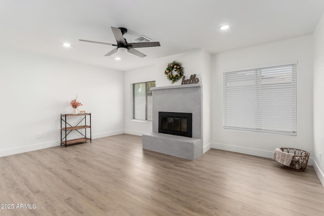 3008 S Saguaro Cir, Mesa, AZ 85202 - unfurnished living room featuring a ceiling fan, a glass covered fireplace, light wood-type flooring, recessed lighting, and baseboards