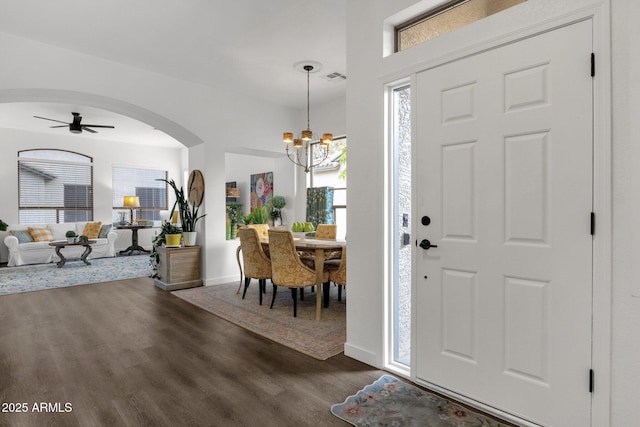 entrance foyer featuring ceiling fan with notable chandelier and dark wood-type flooring