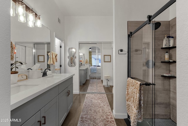 bathroom with hardwood / wood-style floors, vanity, and a shower with shower door