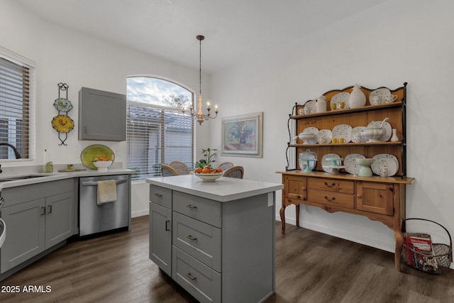 kitchen featuring gray cabinets, sink, stainless steel dishwasher, and decorative light fixtures