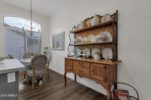 dining room with dark hardwood / wood-style flooring and a notable chandelier