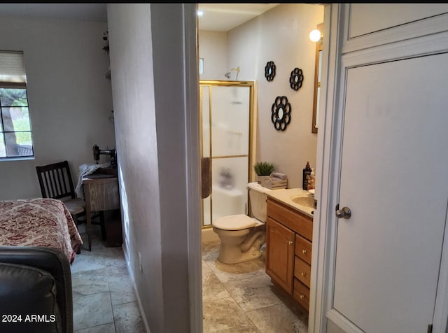 bathroom featuring a shower with door, vanity, and toilet