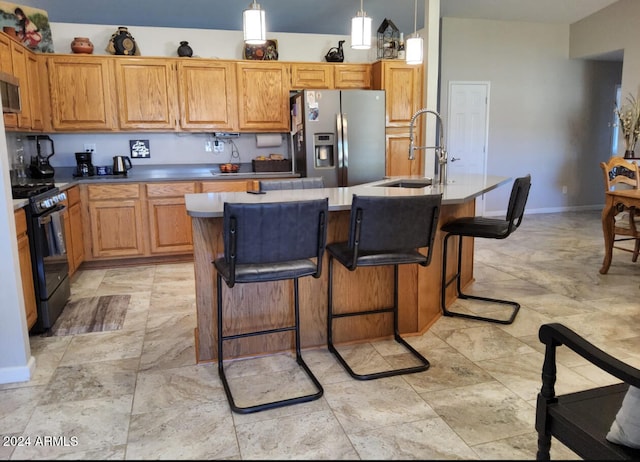 kitchen featuring pendant lighting, stainless steel appliances, sink, and an island with sink