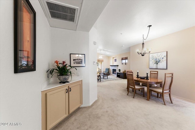 dining space featuring a notable chandelier and light colored carpet