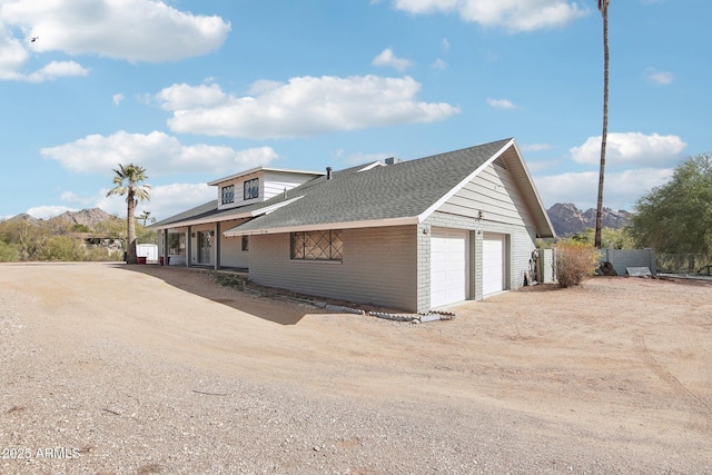 view of side of property featuring a garage and a mountain view