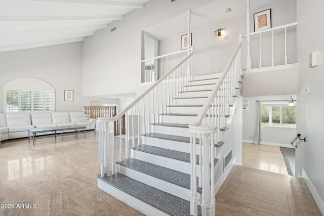 stairs featuring beamed ceiling and high vaulted ceiling