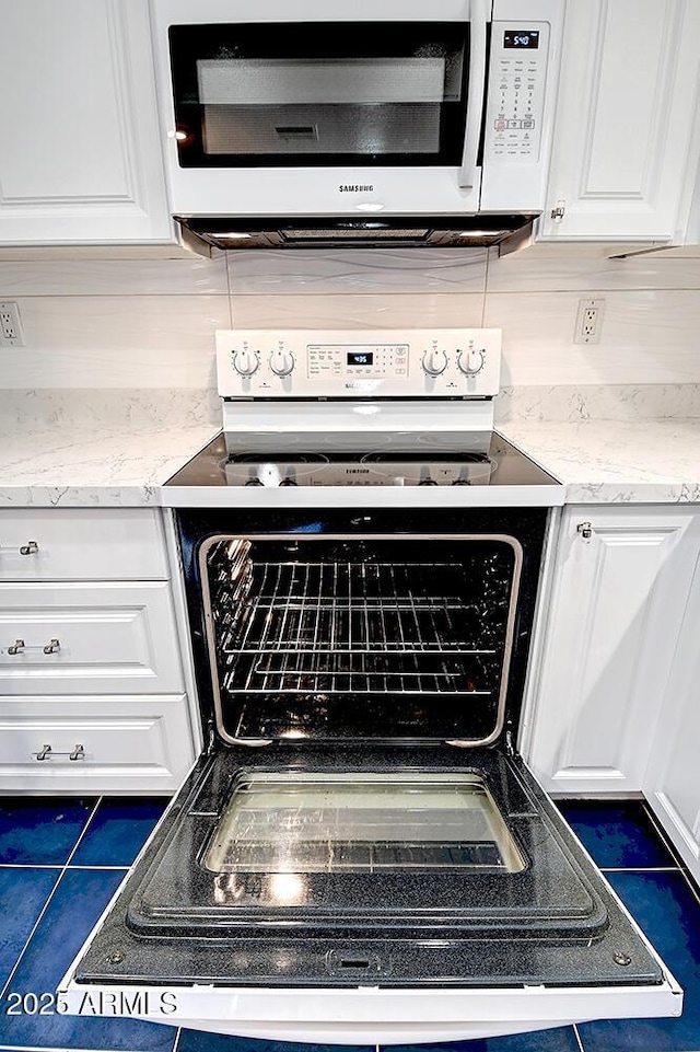 room details with range with electric cooktop, light stone counters, and white cabinets