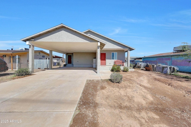 view of front facade featuring an attached carport, fence, and driveway