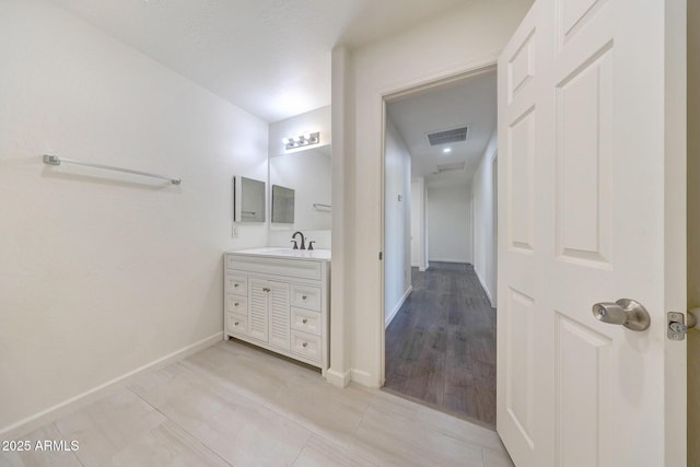 bathroom featuring vanity, baseboards, visible vents, and tile patterned flooring