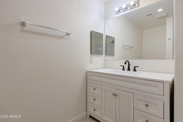 bathroom featuring visible vents, baseboards, and vanity