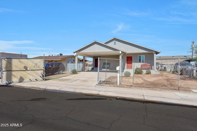 view of front of house with a fenced front yard, an attached carport, concrete driveway, and a gate