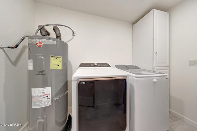 clothes washing area featuring baseboards, cabinet space, separate washer and dryer, and water heater