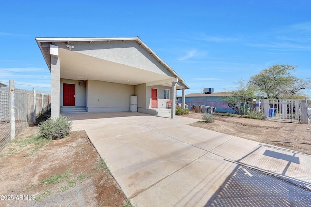 view of front facade featuring stucco siding and fence