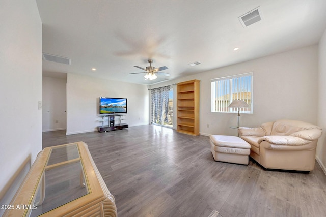 living area featuring visible vents, recessed lighting, baseboards, and wood finished floors