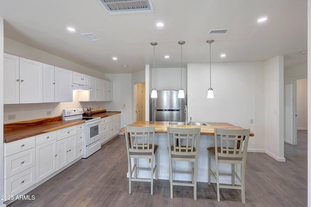 kitchen featuring wooden counters, visible vents, freestanding refrigerator, and white range with electric cooktop