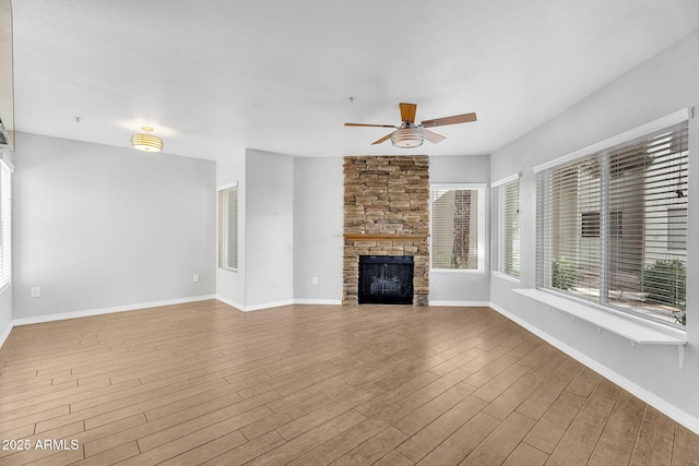 1825 W Ray Rd Unit 1119, Chandler, AZ 85224 - unfurnished living room featuring ceiling fan, a stone fireplace, wood finished floors, and baseboards