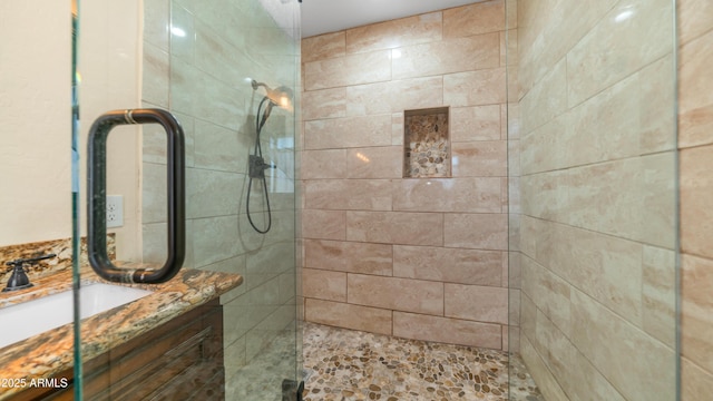 bathroom featuring walk in shower and vanity