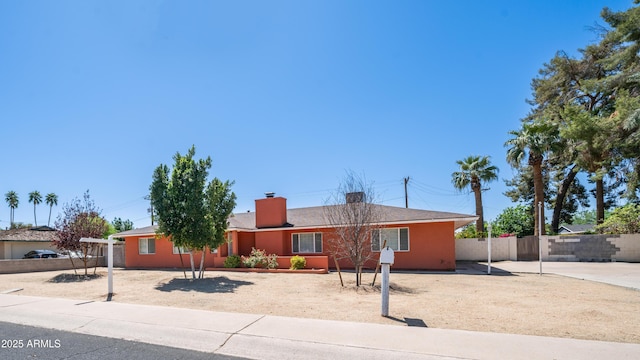 single story home featuring fence and a chimney