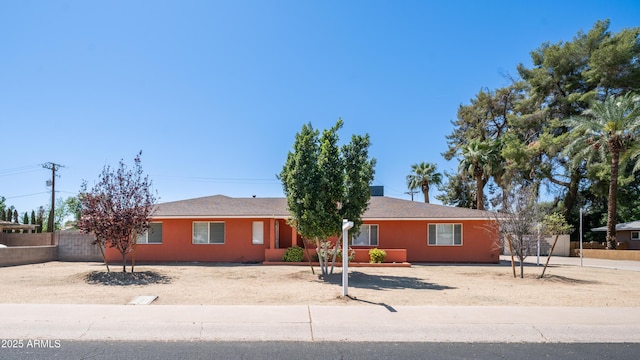 ranch-style home featuring fence