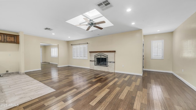 unfurnished living room featuring wood finished floors, visible vents, and a wealth of natural light