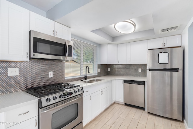 kitchen featuring sink, white cabinets, decorative backsplash, and stainless steel appliances