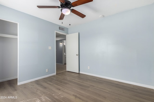 unfurnished bedroom featuring a closet, hardwood / wood-style floors, and ceiling fan