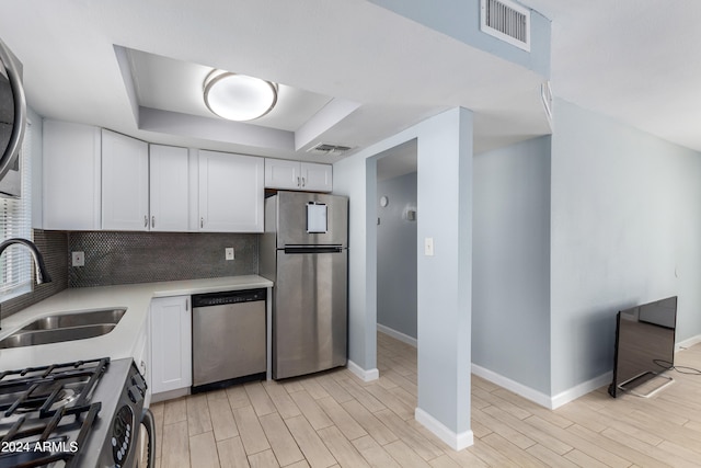 kitchen with light hardwood / wood-style flooring, white cabinetry, stainless steel appliances, and sink