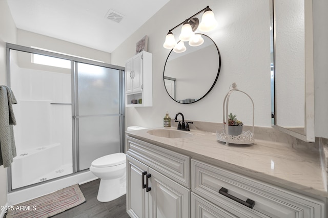 bathroom with vanity, wood-type flooring, toilet, and walk in shower