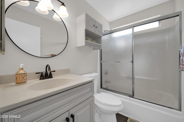 full bathroom with vanity, shower / bath combination with glass door, and toilet