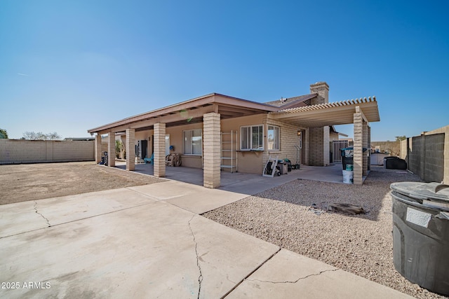 rear view of property featuring a pergola and a patio area