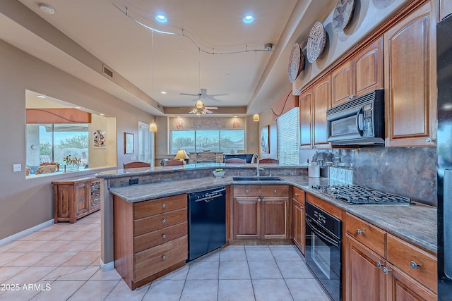 kitchen with black appliances, light tile patterned floors, kitchen peninsula, and sink