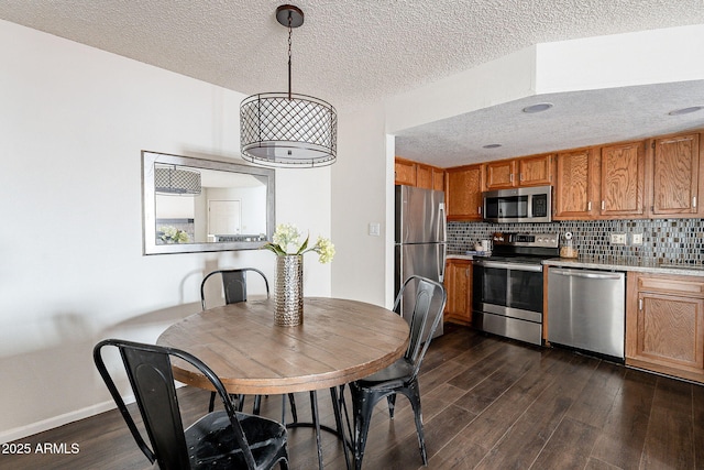 kitchen featuring appliances with stainless steel finishes, dark wood finished floors, and tasteful backsplash