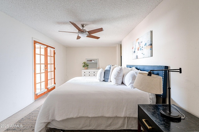 carpeted bedroom with a ceiling fan, french doors, and a textured ceiling