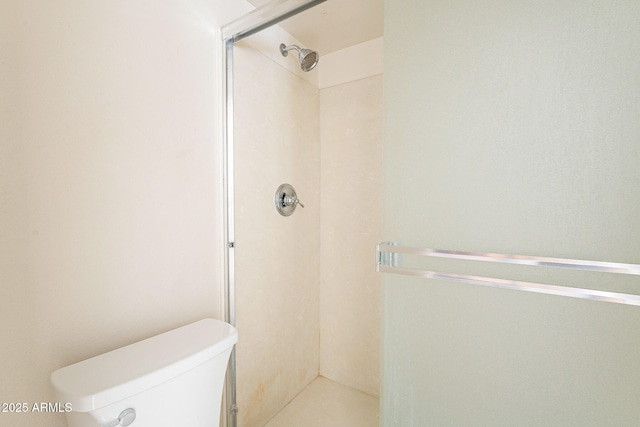 full bathroom featuring a stall shower and toilet