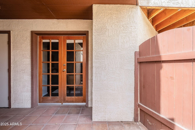 doorway to property featuring french doors and stucco siding