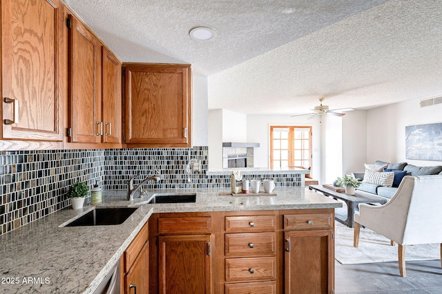 kitchen featuring open floor plan, a peninsula, and backsplash